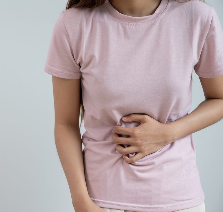 Mujer sosteniéndose el abdomen por la inflamación
